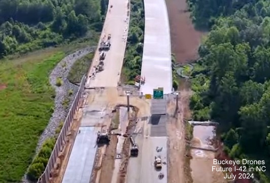 Screen grab image from Buckeye Drones video of new overhead signage with I-40 and US 70 shields on 
       Future NC 540 East at NC 50 interchange, July 2024