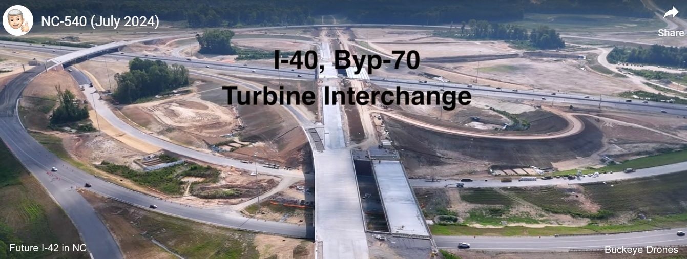 Screen grab image from Buckeye Drones video of the Turbine interchange with I-40 and US 70 shields 
       on Future NC 540 East at NC 50 interchange near completion, July 2024