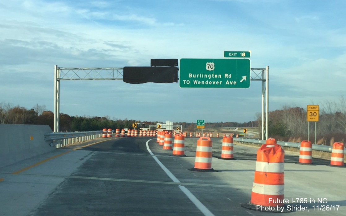 Image of new overhead exit signs for US 70 and for Huffine Mill Rd, covered over, on I-785 North 
           in Greensboro, by Strider