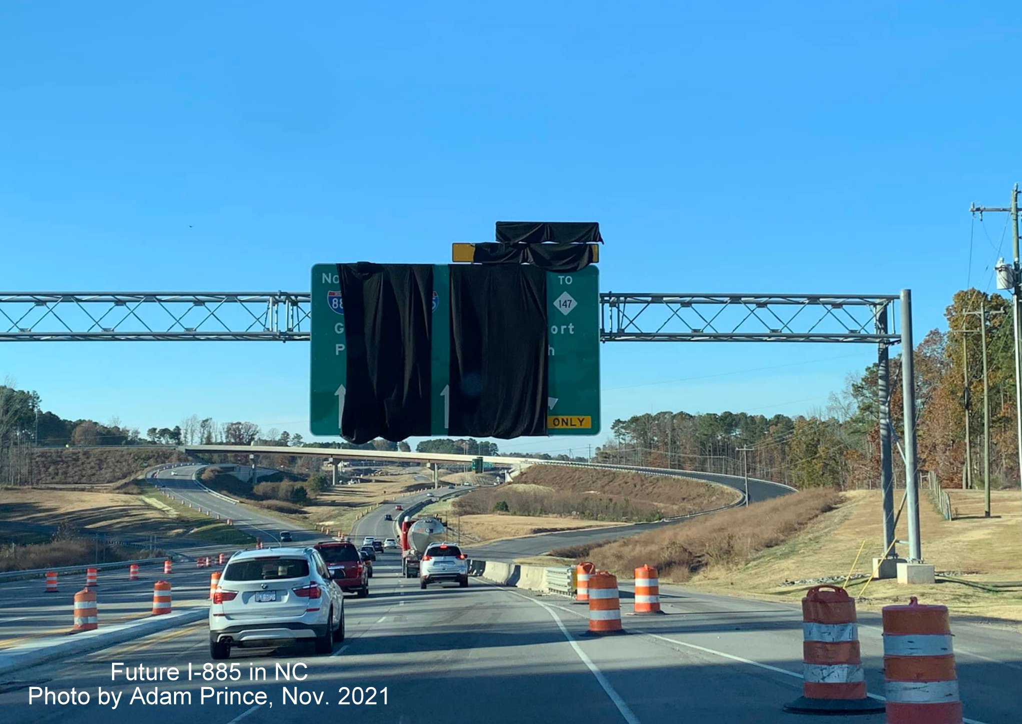 Image of covered over overhead Arrow-per-Lane sign awaiting opening of East End Connector at future ramp to I-885 South on US 70 West in Durham, by Adam Prince November 2021