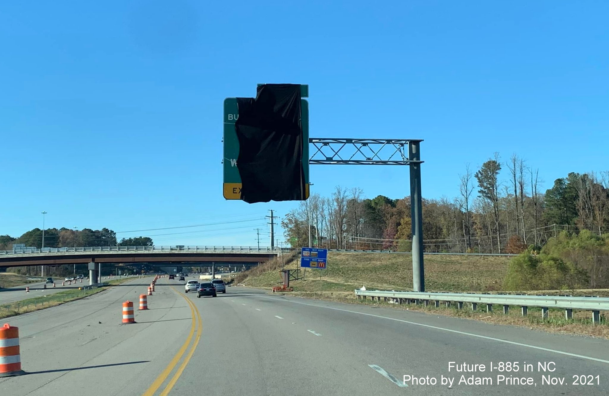 Image of covered over overhead sign for US 70 Business/NC 98 exit awaiting opening of East End Connector on US 70 West in Durham, by Adam Prince November 2021