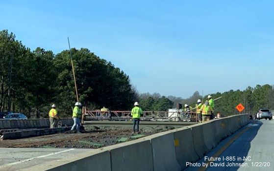 Image of construction workers on railroad bridge for future North NC 147 lanes prior to Briggs Avenue exit in Durham, by David Johnson