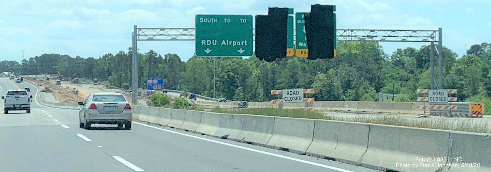 Image of uncovered pull through sign still without shields on future I-885 South lanes as seen from current US 70 East lanes in Durham, by David Johnson in May 2020