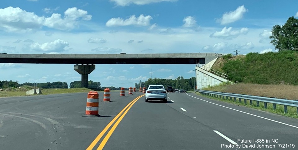 Image of US 70 traffic driving under nearly complete flyover ramp to Future I-885 South in East End Connector Project work zone in Durham, by David Johnson