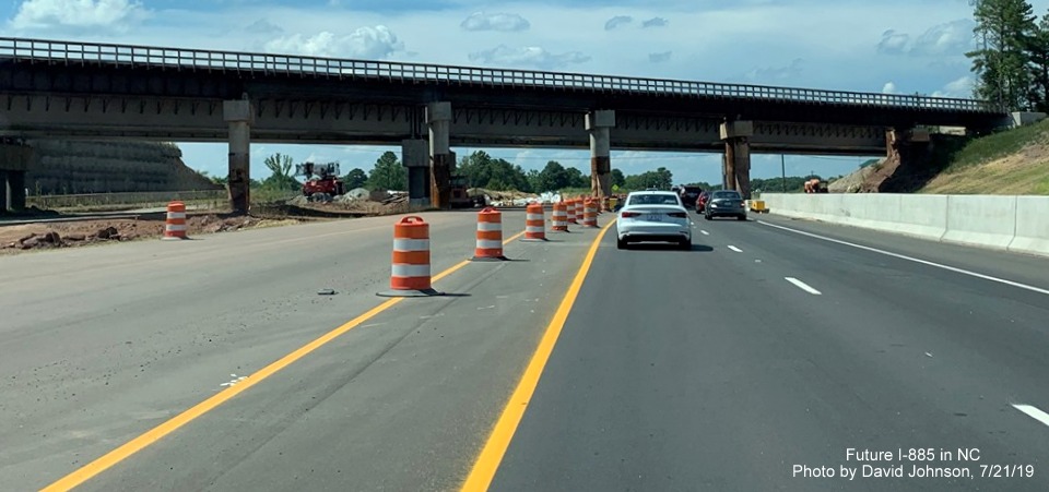 Image of new railroad bridge being constructed behind temporary structure from US 70 West (Future I-885 North) in East End Connector Project work zone in Durham, by David Johnson
