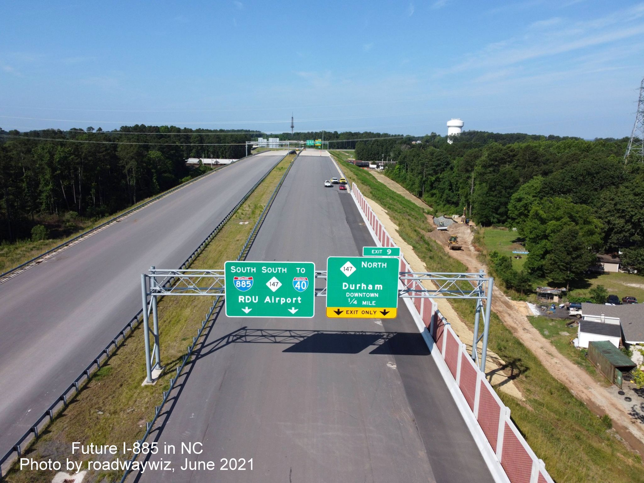 Image of 1/4 mile advance and pull through overhead signs for NC 147/Durham Freeway exit on unopened I-885 South/East End Connector, photo by roadwaywiz, June 2021
