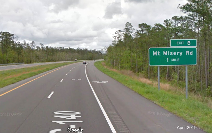 Google Maps Street View image of 1-mile advance ground mounted sign for Mt Misery Road exit on I-140 East, taken in April 2019