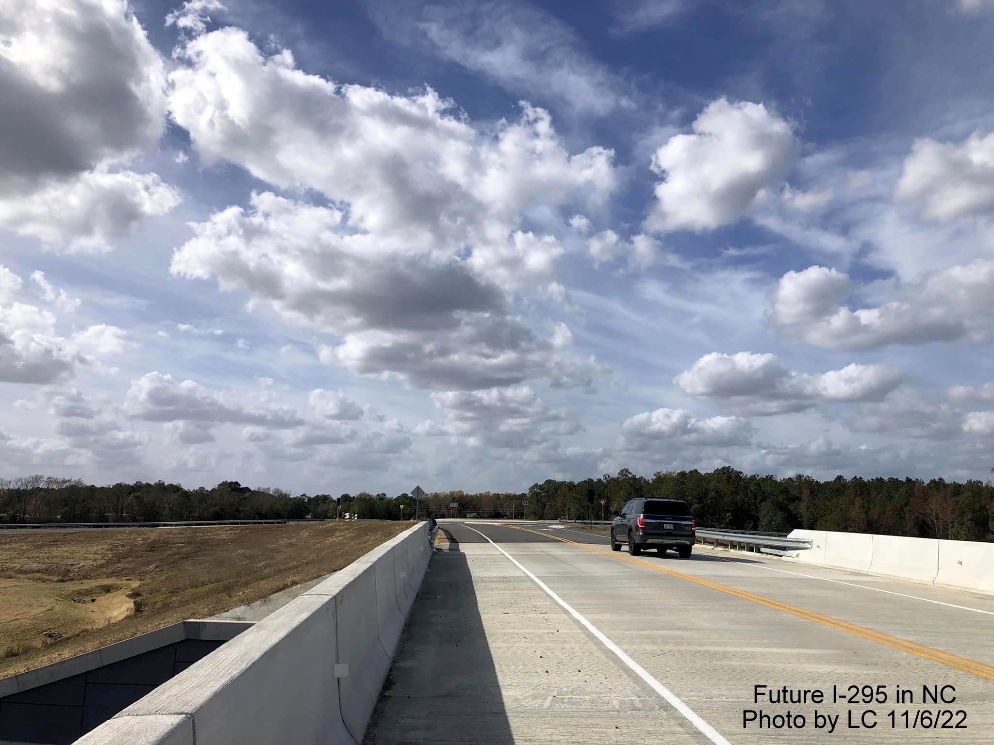 Image taken looking west along Black Bridge Road bridge toward new roundabout with ramps for soon to 
        be opened section of Fayetteville Outer Loop to Parkton/Leeper Roads, by LC, November 2022