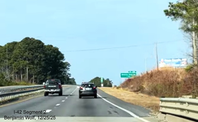 Image of beginning of US 70 freeway following the Neuse River bridge, shoulders not
	at interstate standard, screen grab from Benjamin Wolf video, December 2025