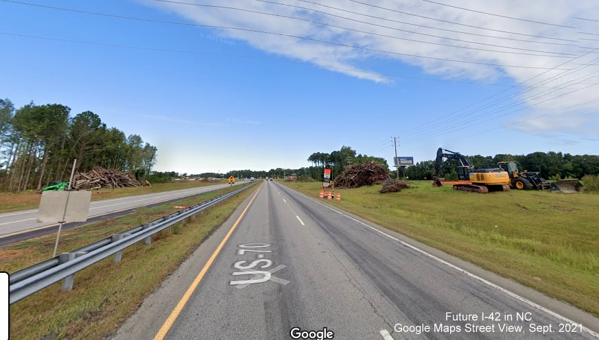 Image of construction vehicles at site of future interchange at  Road from US 70 East, Google Maps Street View image, September 2021