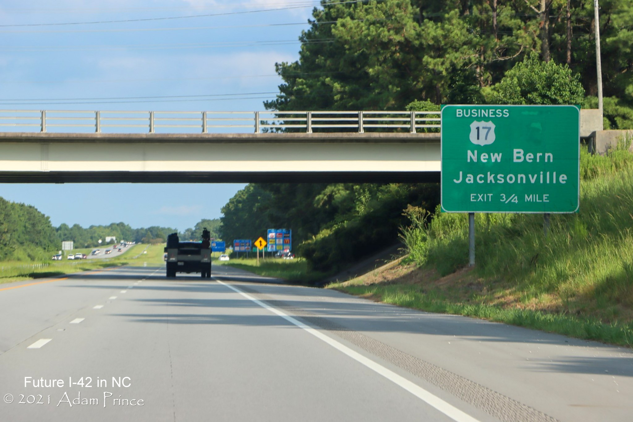 Image of US 17 South exit sign with removed Business 70 shield along newly widened right shoulder of US 70 (Future I-42) East in Craven County, photo by Adam Prince, July 2021