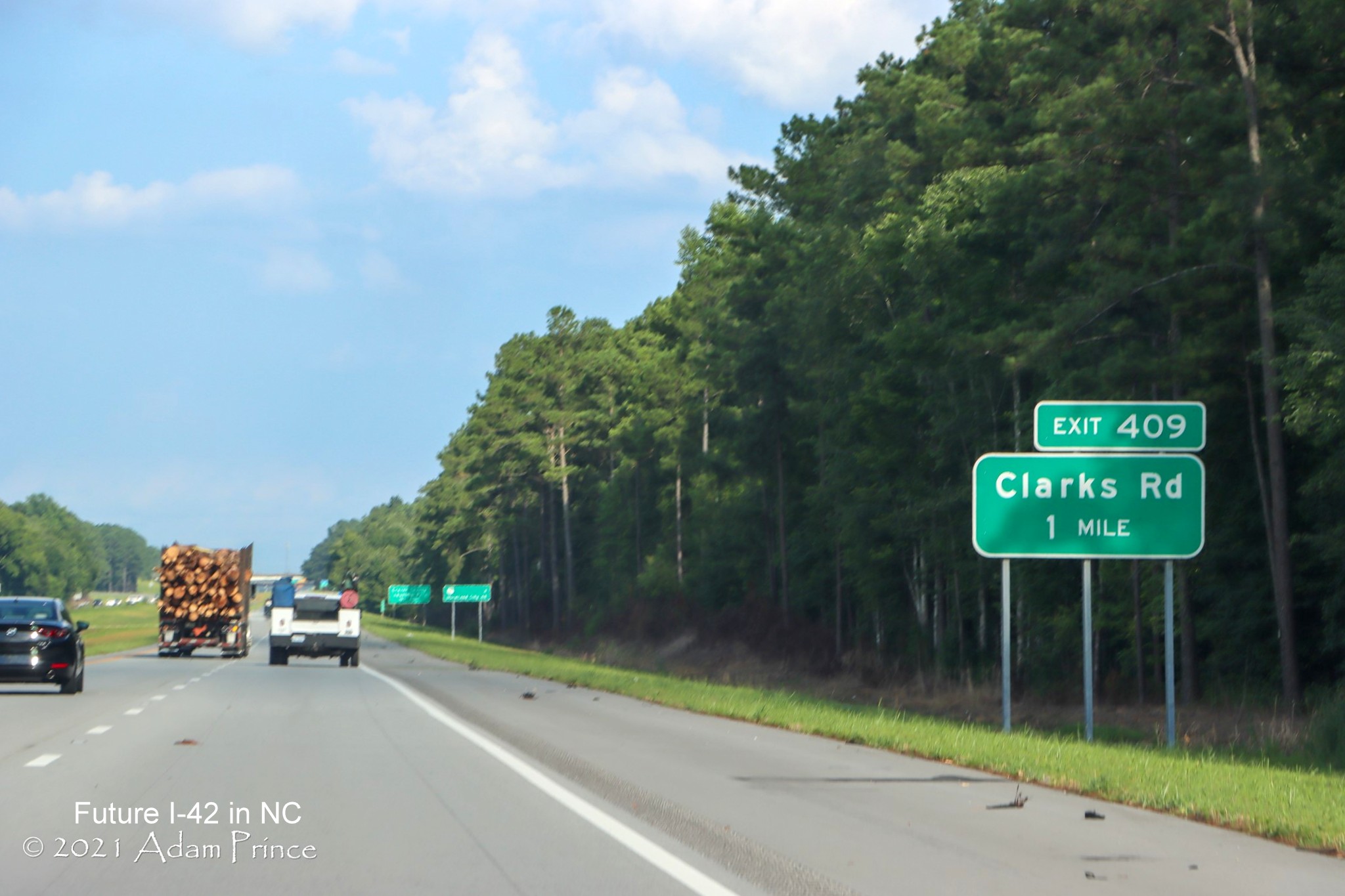 Image of Clark Road exit sign with exit number along newly widened right shoulder of US 70 (Future I-42) East in Craven County, photo by Adam Prince, July 2021