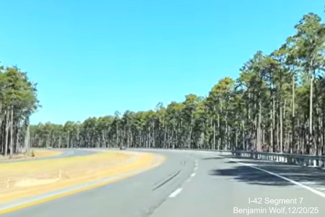 Image of Bypass taking a curve through pine trees on US 70 (Future 
	I-42) West Havelock Bypass, Screen grab from Benjamin Wolf video, December 2025