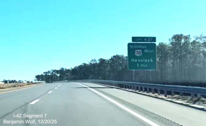 Image of 1 Mile advance sign for the Business US 70 West exit on the US 
	70 (Future I-42) East Havelock Bypass, Screen grab from Benjamin Wolf video, December 2025