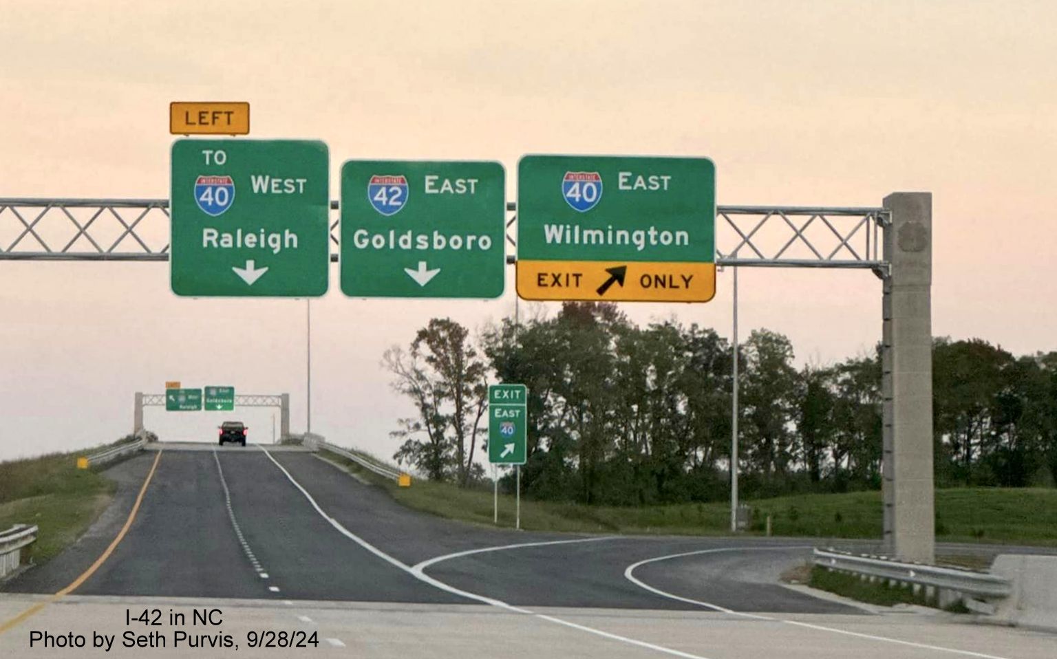 Image of overhead sign for I-40 and I-42 exits from current end of NC 540/Triangle Expressway at 
        the Turbine Interchange, by Seth Purvis, September 2024