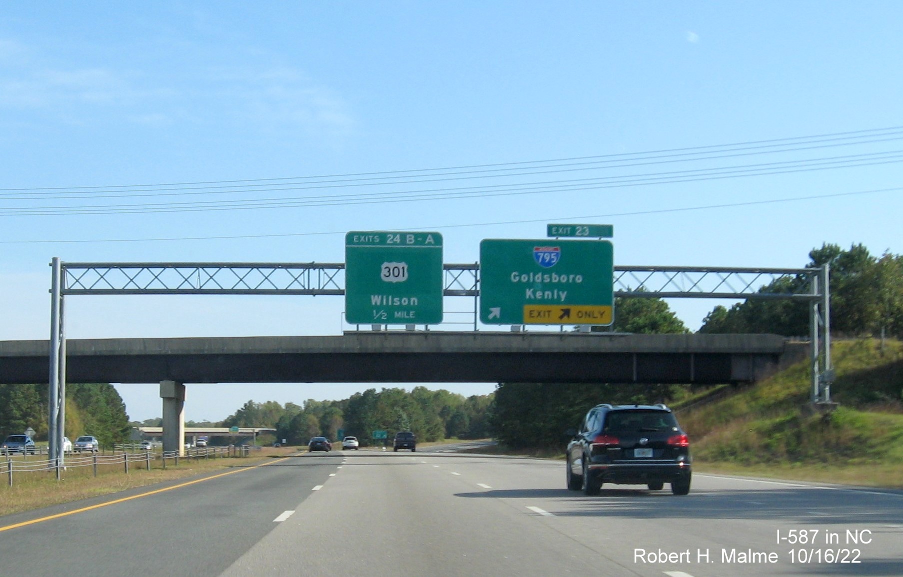 Image of overhead signage at ramp for I-795 South exit with new I-587 milepost exit number on I-587/US 264 East,I-795 
                                        South in Wilson, October 2022