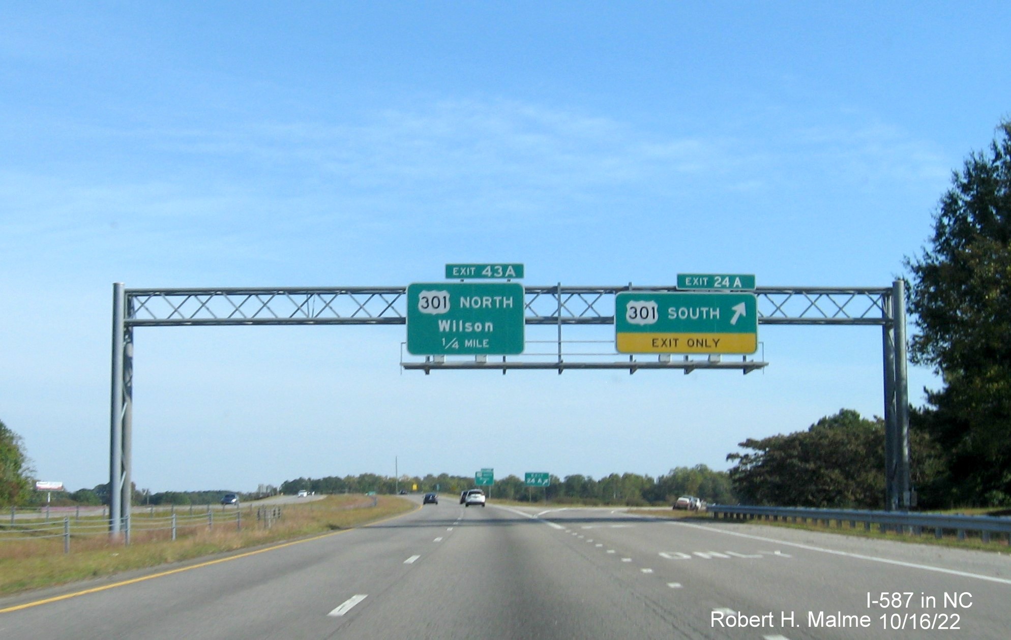 Image of overhead signs at ramp for US 301 South exit with new I-587 milepost exit number on I-587/US 264 East in Wilson, October 2022