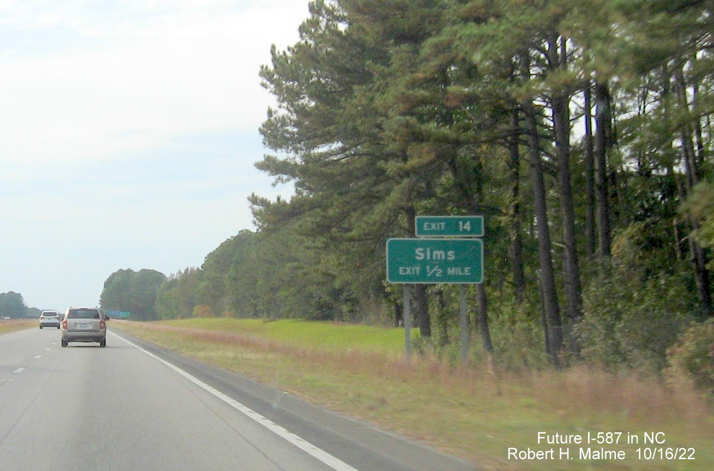 Image of ground mounted 1/2 mile advance sign for Sims exit with new I-587 milepost exit number on US 264 East in Sims, October 2022
