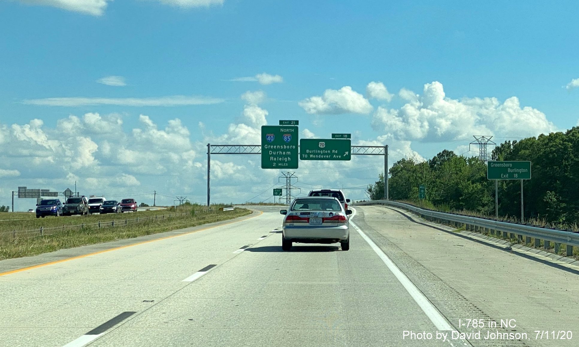 Image of overhead signage at US 70 exit on I-785 South Greensboro Urban Loop with small ground mounted Burlington auxiliary sign, by David Johnson July 2020