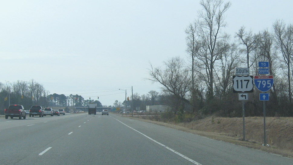 Photo of signage on US 301 south that distinguish between intersection for US 
117 back on its old route, and I-795 on the former US 117 freeway, Jan. 2010