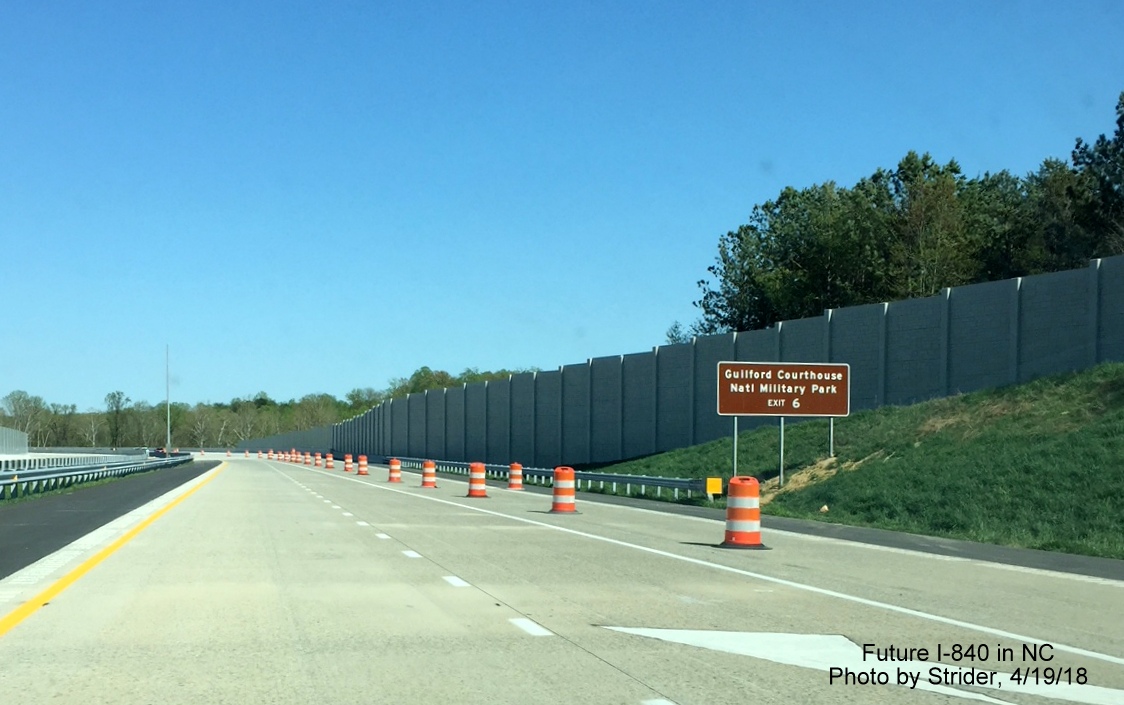 Image of brown auxiliary sign and sound walls along newly opened section of I-840/Greensboro Urban Loop approaching US 220, by Strider