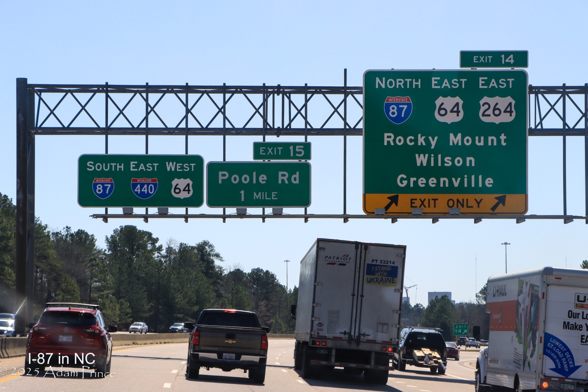 Image of overhead signs at I-87 North/I-440 West/US 64 East exit on I-440 East/US 64 West 
         in Raleigh, by Adam Prince, March 2025