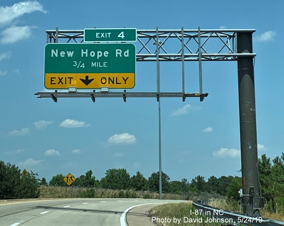 Image of 1/2 mile advance overhead sign for New Hope Road with new I-87 exit number tab on ramp from I-440 West, by David Johnson