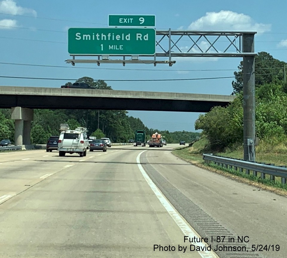 Image of 1-Mile advance overhead sign for Smithfield Road exit with new I-87 exit number tab on I-87 North, US 64/264 East in Knightdale, by David Johnson