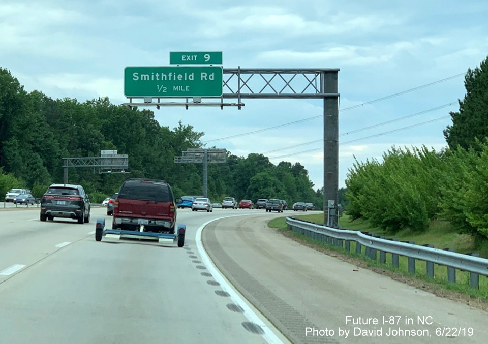 Image of overhead 1/2 mile advance sign for Smithfield Road exit with new I-87 exit number tab on I-87 South, US 64/264 West in Knightdale, by David Johnson