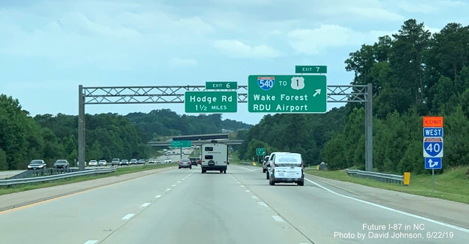 Image of overhead signs with new I-87 exit number tabs at I-540 exit on I-87 South, US 64/264 West in Knightdale, by David Johnson