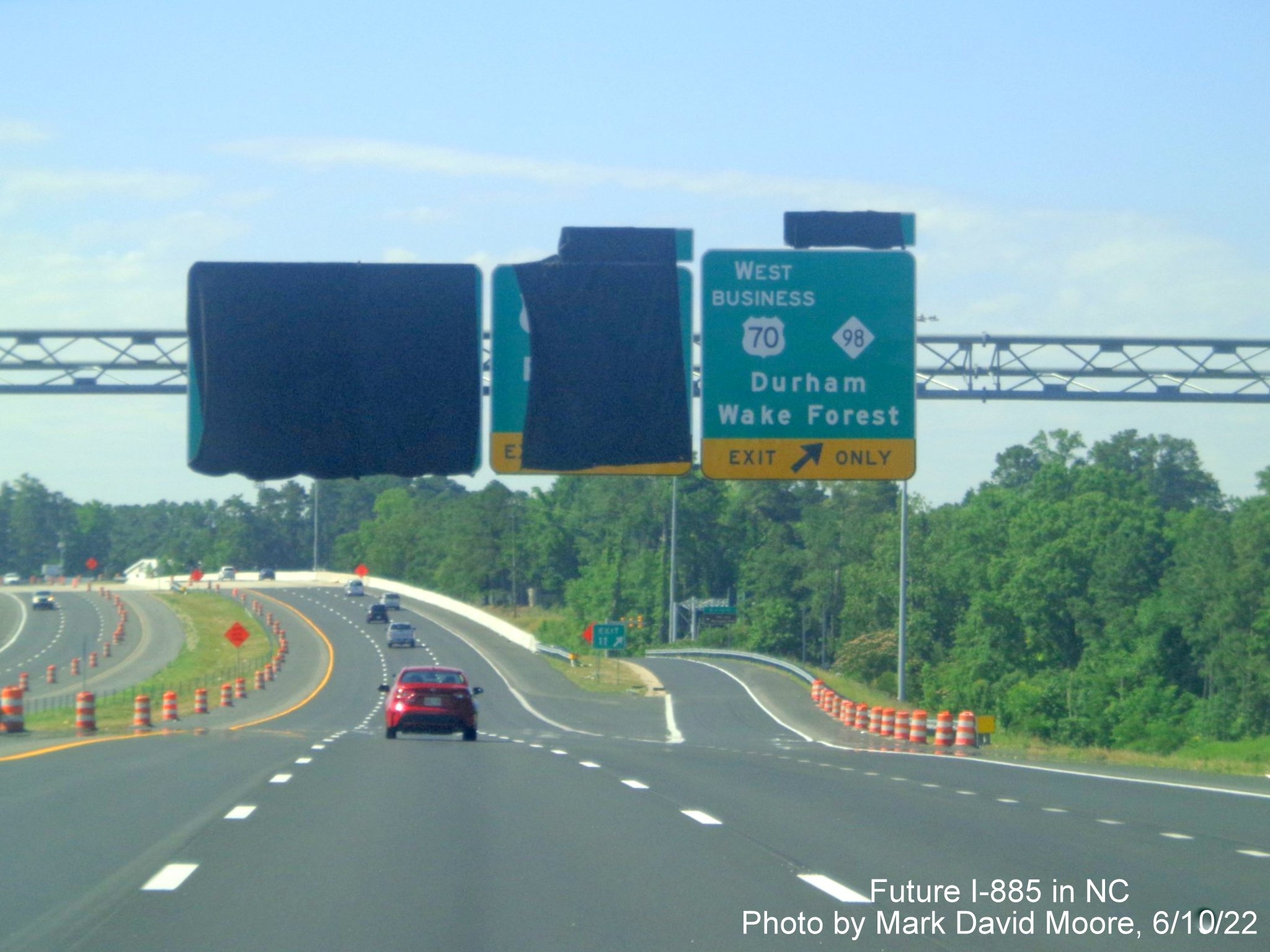 Image of overhead signage at ramp for US 70 Bus. West/NC 98 exit
       with exit tab still covered over on Future I-885 South/US 70 East in Durham, by Mark David Moore June 2022